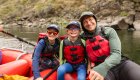 A dad and his two sons posing for a photo while on a rafting trip in Idaho