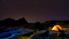 A starry nights sky over tents and kayaks at beach camp in Baja, California Sur
