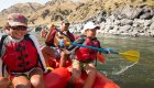 Kids paddling a whitewater raft with their parents in the back on the Salmon River