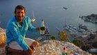 Tour guide in Turkey sitting at an ocean overlook pouring a glass of wine and smiling