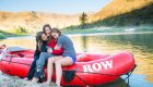mom and daughters hugging while sitting on raft