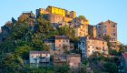 A historic hilltop village in Corsica rises above the surrounding landscape, a highlight of cultural exploration on guided Corsica travel itineraries.