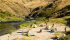tents on white sandy beach on the edge of the salmon river