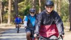 Guests cycling together on a shaded forest trail during a guided Oregon bike tour