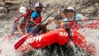 red whitewater raft with people in rapids