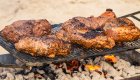 Juicy steaks sizzling over a campfire grill on a Middle Fork Salmon rafting trip, combining riverside camping and delicious meals along the Salmon River.