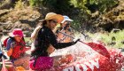 woman paddling in red whitewater raft