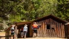 people standing in front of old wooden cabin