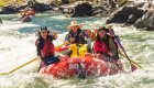 people in whitewater raft in rapids on river