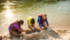 kids playing in the sand along the river