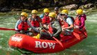 red whitewater raft with people floating in green water