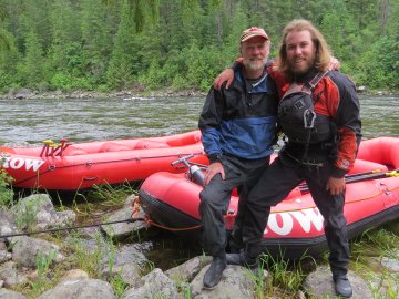 two men in pfds in front of red raft