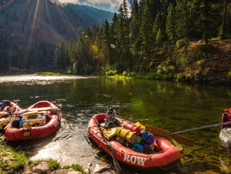 Loaded rafts drifting through calm water on the Middle Fork of the Salmon River, capturing a peaceful pause between whitewater and wilderness camps.