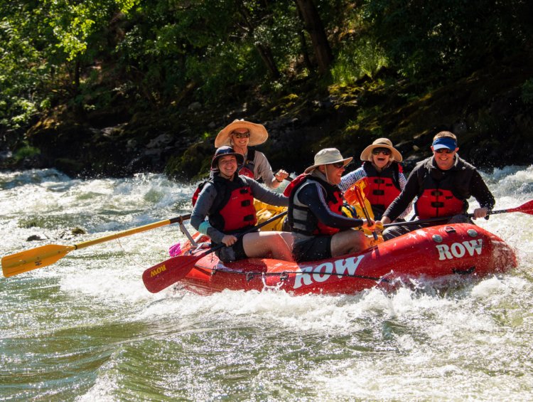 red raft with 5 people on the rogue river in Oregon
