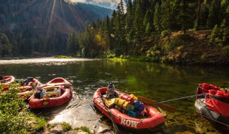 Loaded rafts drifting through calm water on the Middle Fork of the Salmon River, capturing a peaceful pause between whitewater and wilderness camps.