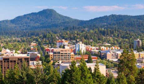 Downtown Eugene, Oregon with surrounding forested hills, showcasing the city’s blend of urban energy and outdoor adventure.