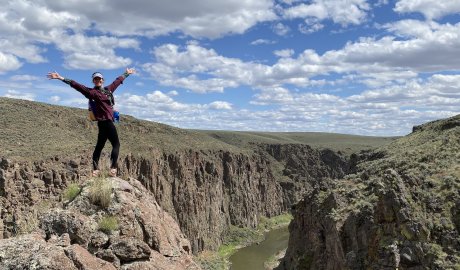 A woman standing at an an overlook of the Owyhee river in Oregon. 