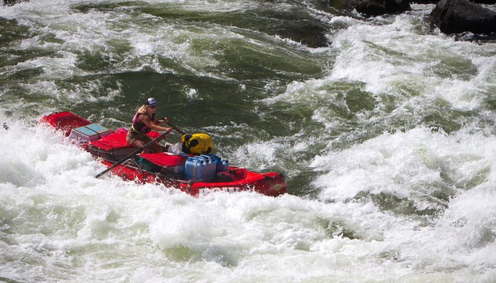 Woman rowing through whitewater rapids