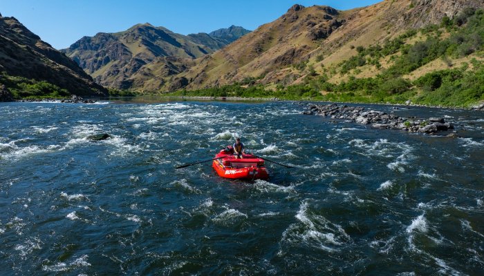 Group of people whitewater rafting through rapids on a guided river trip, an exciting short vacation idea for adventure travel in the Pacific Northwest.