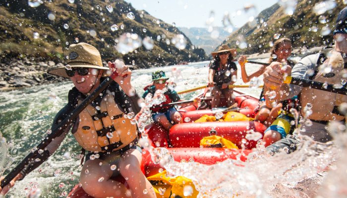 People paddling through a splashy rapid on a warm summer days on the Salmon River