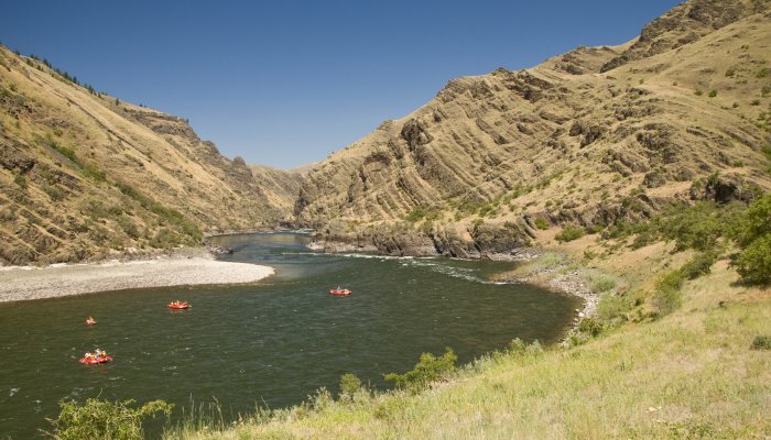 Four red rafts floating down the Salmon River from above