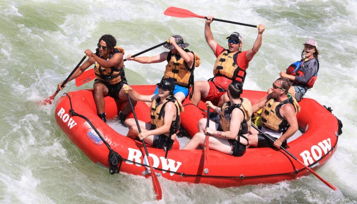 red whitewater raft with seven people paddling